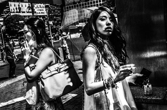 渋谷スクランブル交差点でタバコを吸う二人の若い女性、モノクロ写真